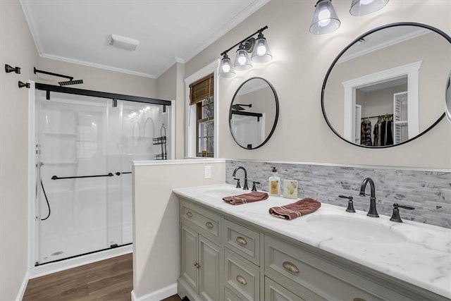 bathroom with ornamental molding, hardwood / wood-style floors, and a shower with shower door