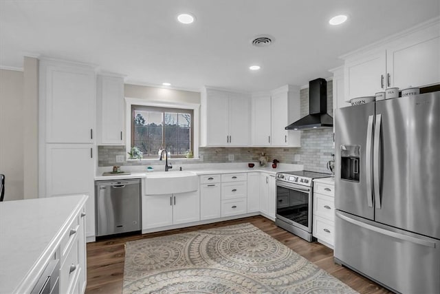 kitchen featuring white cabinetry, sink, dark hardwood / wood-style flooring, stainless steel appliances, and wall chimney range hood