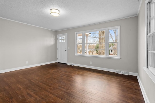 foyer with ornamental molding, dark hardwood / wood-style flooring, and a textured ceiling