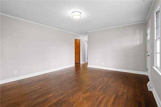 empty room with ornamental molding, plenty of natural light, a textured ceiling, and dark hardwood / wood-style flooring