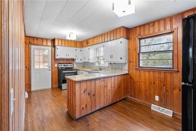 kitchen featuring black refrigerator, white cabinetry, sink, electric range, and kitchen peninsula