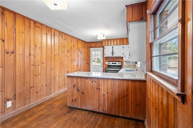 kitchen with stainless steel electric range oven, plenty of natural light, white cabinets, and kitchen peninsula