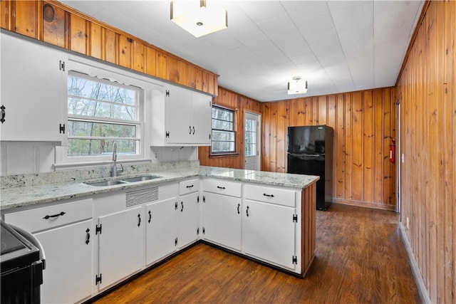 kitchen featuring sink, white cabinetry, black appliances, light stone countertops, and kitchen peninsula