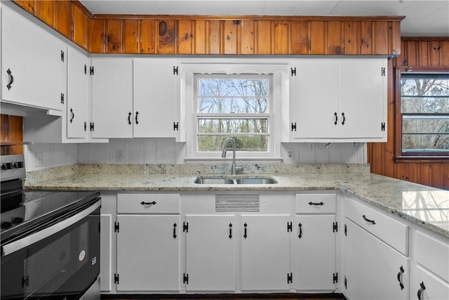 kitchen featuring white cabinetry, plenty of natural light, sink, and stainless steel electric range