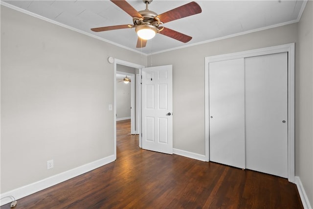 unfurnished bedroom with ceiling fan, ornamental molding, dark hardwood / wood-style floors, and a closet