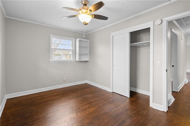 unfurnished bedroom with ornamental molding, dark wood-type flooring, and a closet