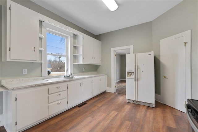 kitchen featuring white cabinetry, white fridge with ice dispenser, and dark hardwood / wood-style flooring