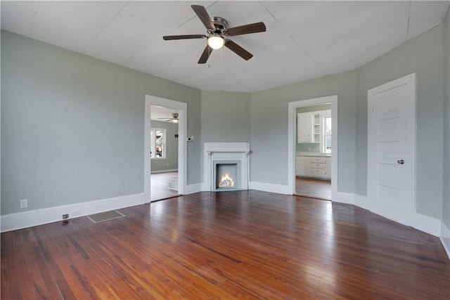 unfurnished living room featuring ceiling fan and dark hardwood / wood-style floors