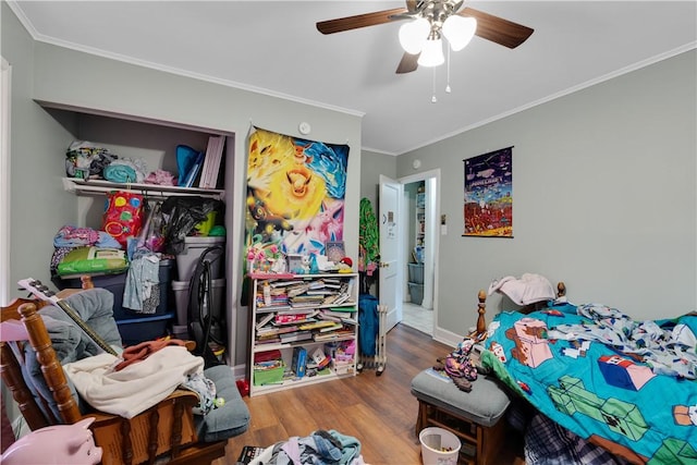 bedroom featuring ornamental molding, hardwood / wood-style floors, ceiling fan, and a closet