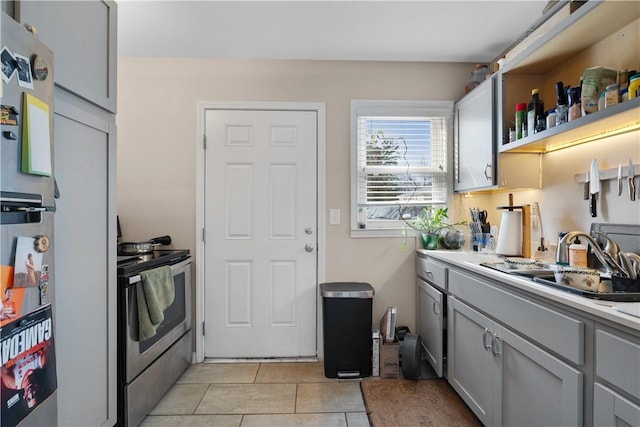 kitchen featuring gray cabinets, light tile patterned flooring, sink, and stainless steel appliances