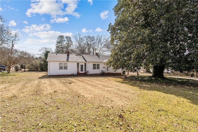 rear view of property with a lawn