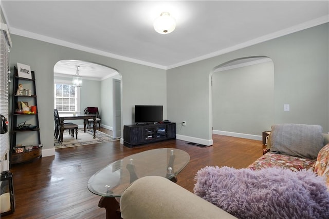 living room with crown molding, dark hardwood / wood-style floors, and a notable chandelier