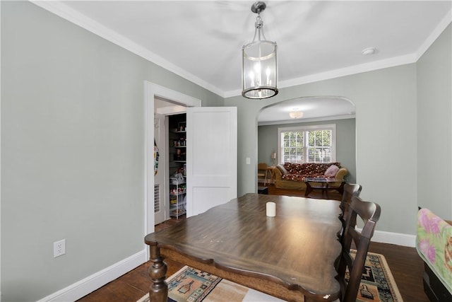 dining room with dark hardwood / wood-style flooring and crown molding