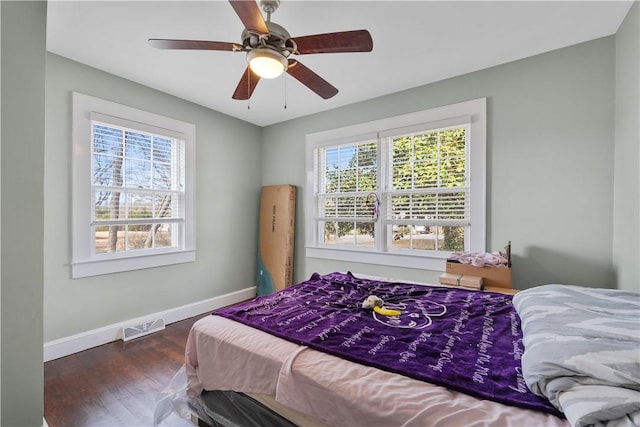 bedroom with dark hardwood / wood-style floors and ceiling fan