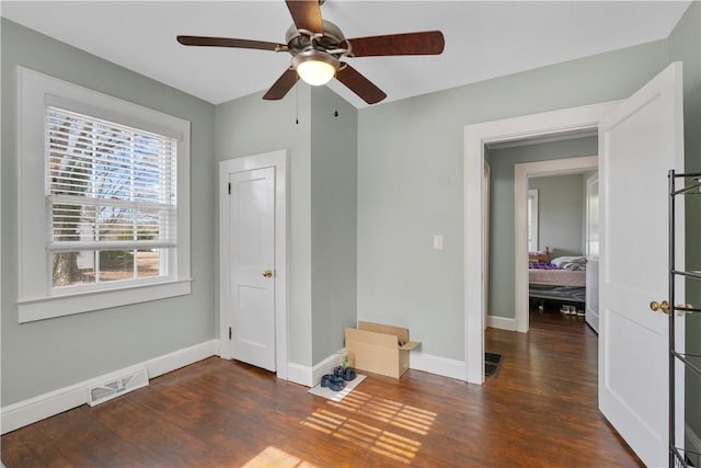 interior space featuring dark wood-type flooring and ceiling fan