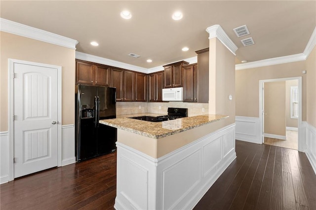 kitchen featuring light stone counters, dark hardwood / wood-style floors, black appliances, and kitchen peninsula