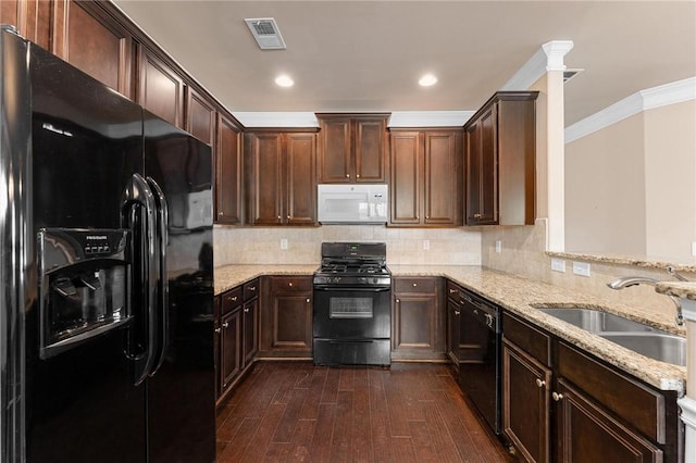 kitchen with sink, crown molding, black appliances, light stone countertops, and backsplash