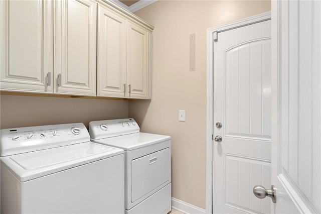 clothes washing area featuring separate washer and dryer and cabinets