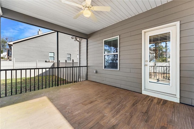 unfurnished sunroom with ceiling fan