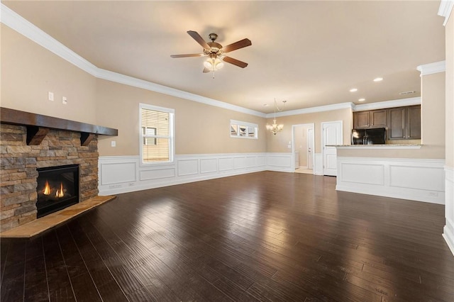 unfurnished living room featuring ceiling fan, a fireplace, ornamental molding, and dark hardwood / wood-style flooring