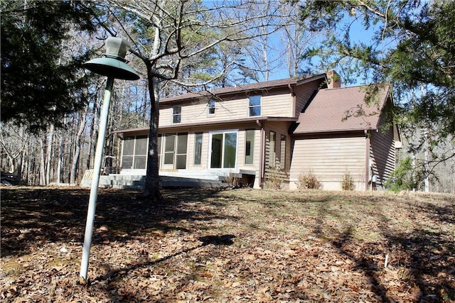 rear view of house featuring a sunroom