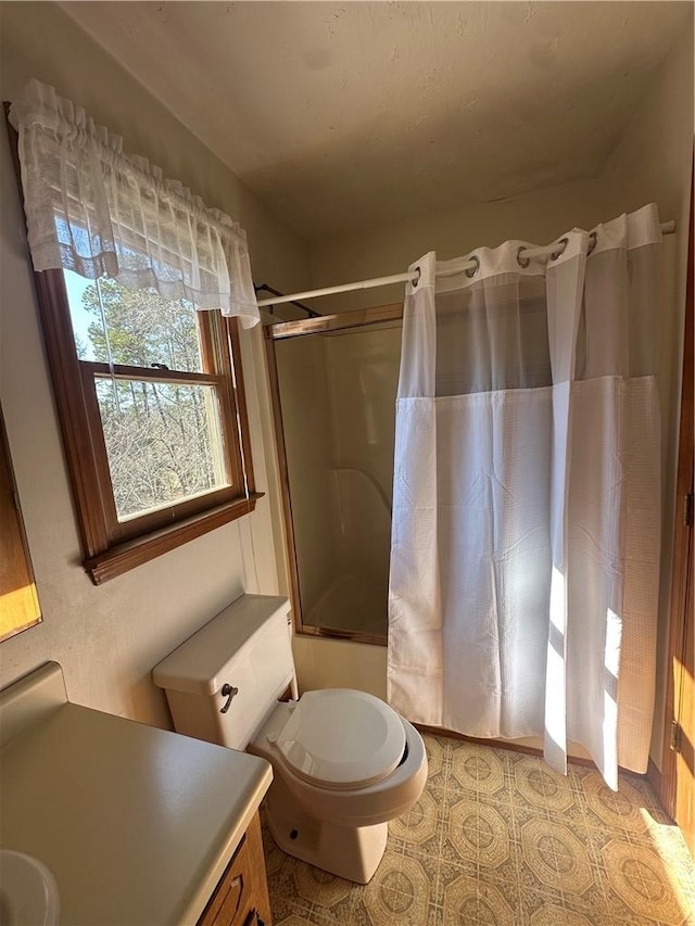 bathroom featuring tile patterned flooring, shower / tub combo with curtain, and toilet