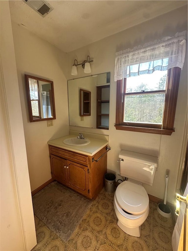 bathroom featuring tile patterned flooring, vanity, and toilet