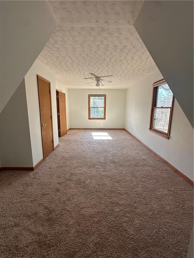 additional living space featuring ceiling fan, a textured ceiling, and carpet flooring