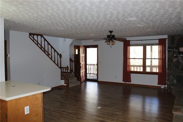 unfurnished living room featuring dark hardwood / wood-style flooring, a wealth of natural light, and a textured ceiling