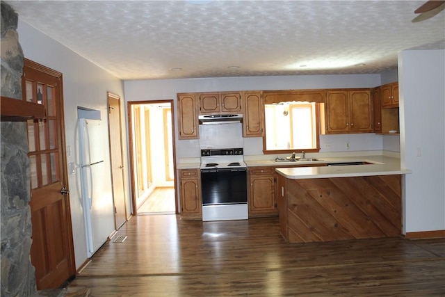 kitchen featuring range with electric cooktop, white refrigerator, hardwood / wood-style floors, and a textured ceiling