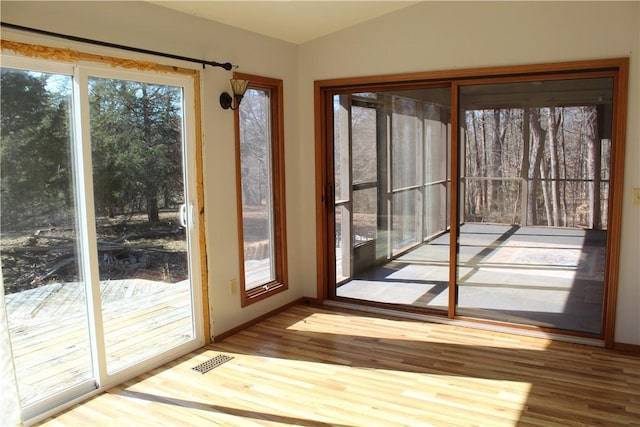 doorway to outside featuring wood-type flooring and lofted ceiling