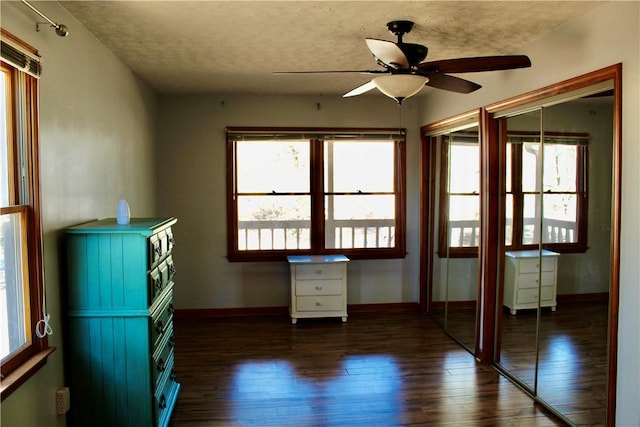 interior space with plenty of natural light, dark hardwood / wood-style floors, a textured ceiling, and ceiling fan