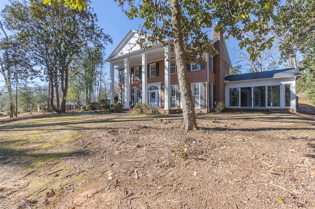 greek revival inspired property featuring a sunroom