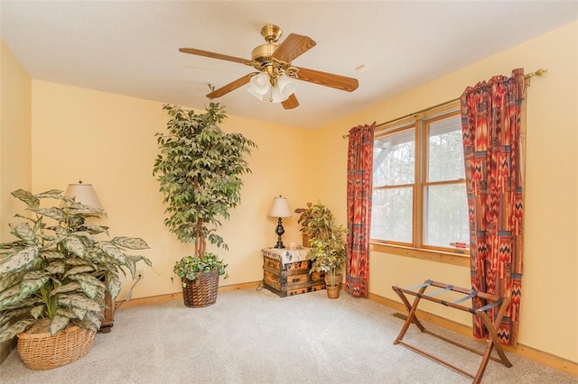 living area featuring carpet floors and ceiling fan