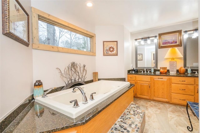 bathroom featuring vanity and a washtub