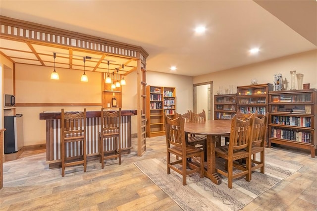 dining room featuring light hardwood / wood-style floors and bar area