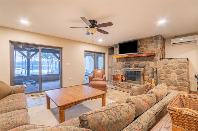 living room featuring a fireplace, an AC wall unit, and ceiling fan