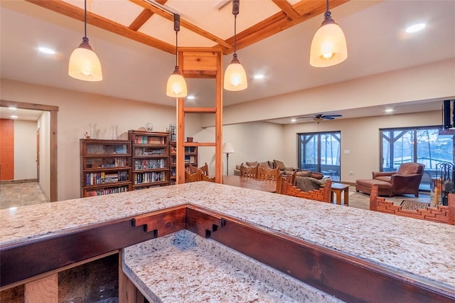 kitchen with hanging light fixtures, light stone countertops, and ceiling fan