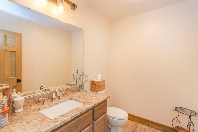 bathroom featuring hardwood / wood-style flooring, vanity, and toilet