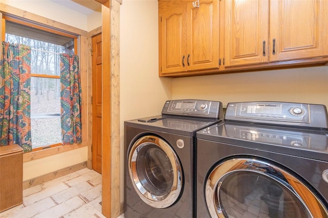 clothes washing area featuring cabinets and washer and dryer