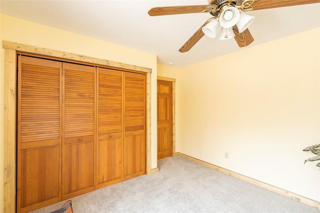 unfurnished bedroom with light colored carpet, a closet, and ceiling fan