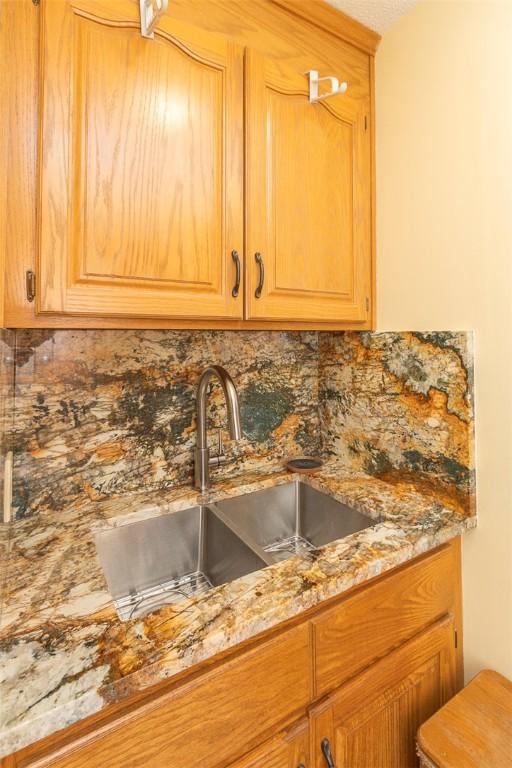 kitchen featuring light stone countertops, sink, and decorative backsplash