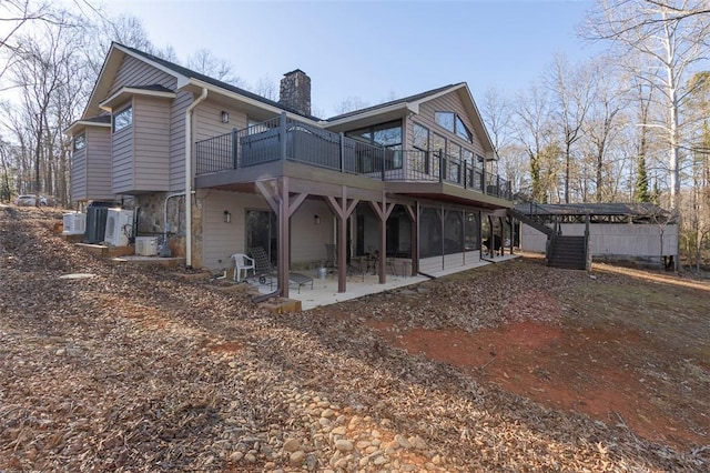 back of house featuring a deck and a patio area