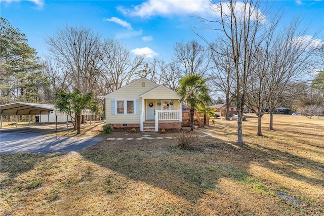 view of front of house with a carport, covered porch, and a front lawn