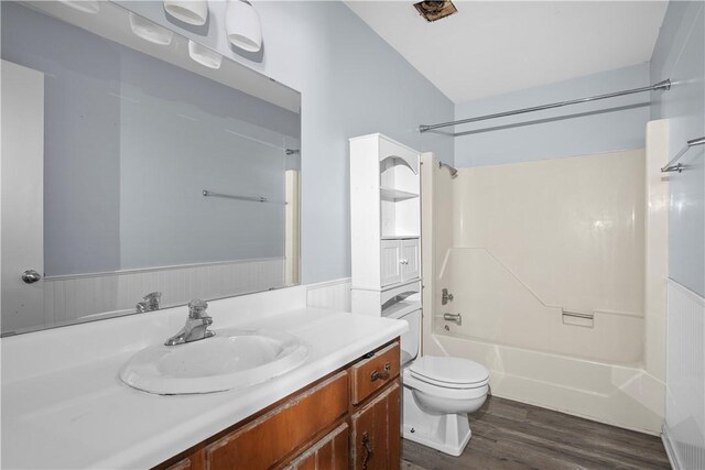 full bathroom with wood-type flooring, vanity, shower / bathtub combination, and toilet