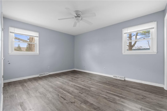 spare room with wood-type flooring, a wealth of natural light, and ceiling fan