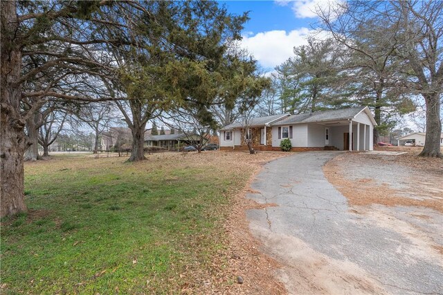 single story home with a front yard and a carport