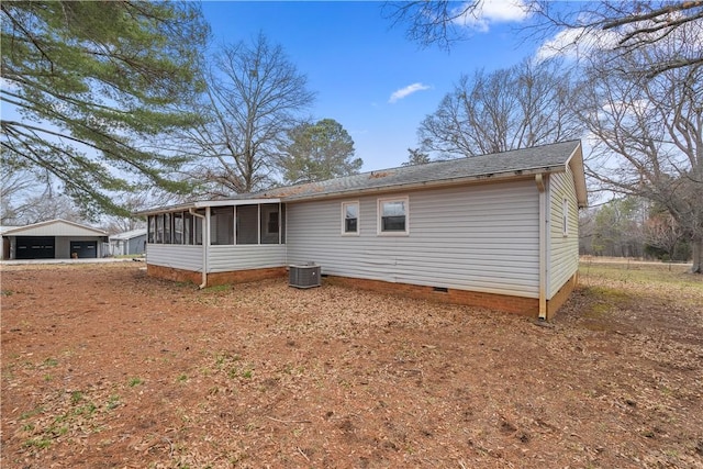 back of property with central AC, a garage, and a sunroom