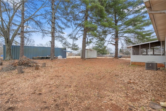 view of yard featuring cooling unit, a storage shed, and a sunroom