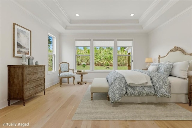 bedroom featuring a raised ceiling, ornamental molding, and light hardwood / wood-style floors